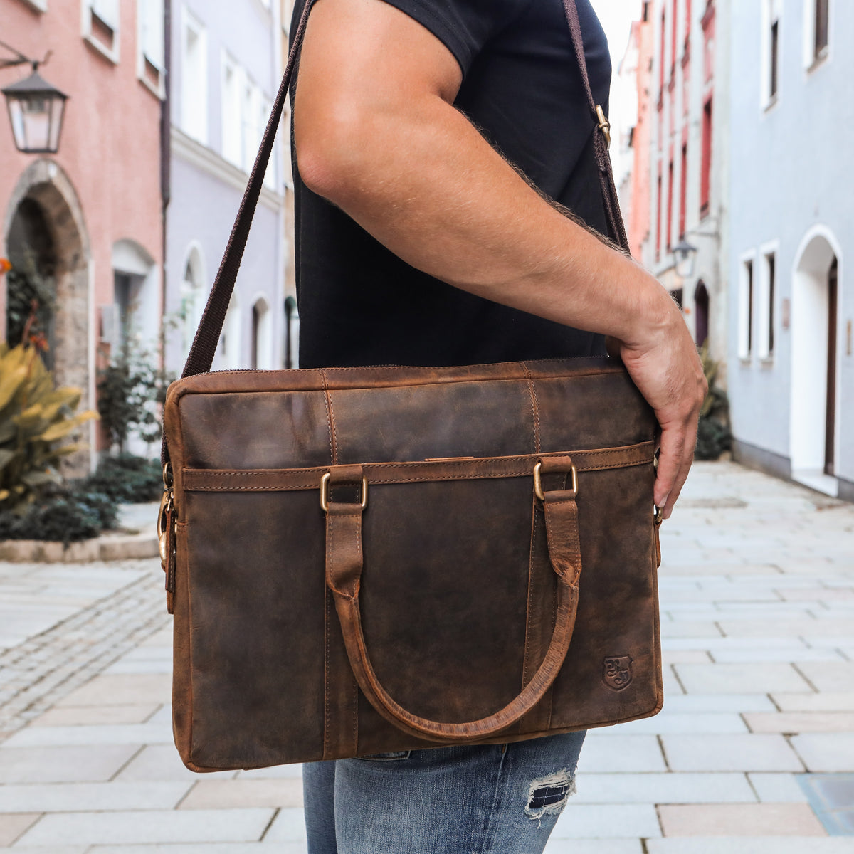 Mann trägt braune Hodalump Laptoptasche aus Leder mit Schulterriemen in der Stadt.